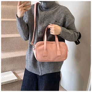 Pink matte Boston bag worn by model, showing shoulder strap and silver hardware details