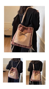 Détail d'un sac à dos à carreaux rouge et bleu avec poche en peluche beige et nœud