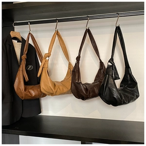 Detailed display of four retro pleated leather bags with knotted strap and metal zippers
