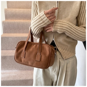 Detail of vintage brown suede Boston bag showing white stitching and matte texture