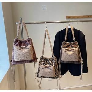 Vue détaillée des sacs à cordon en peluche avec motifs à carreaux et nœuds en polaire