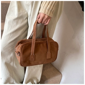 Detail of vintage brown suede Boston handbag with premium matte texture and top handles