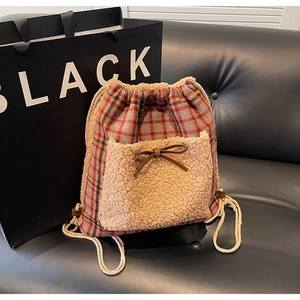 Détail du sac à dos à carreaux d'automne avec poche peluche et nœud en cuir brun