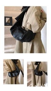 Detail of a large black oversized hobo bag with unique knot shoulder strap design