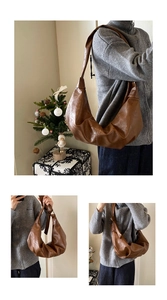 Detail view of dark brown faux leather croissant bag with stylish crescent moon pleats