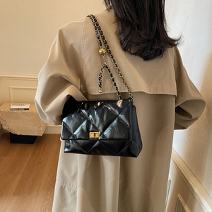 Quilted black leather shoulder bag with gold chain strap and metal ball adjuster