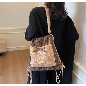 Détail du sac à carreaux d'automne avec poche en peluche beige et nœud en cuir décoratif