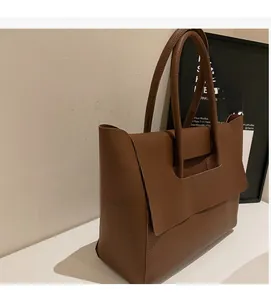 Gros plan sur le cuir grainé marron et la texture d'un grand sac cabas minimaliste