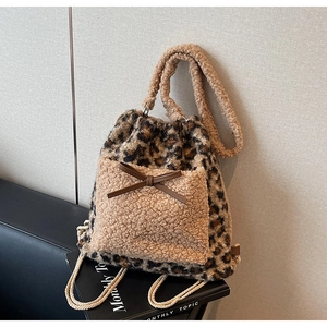 Détail d'un sac à dos en peluche léopard avec poche kaki et nœud décoratif en cuir marron