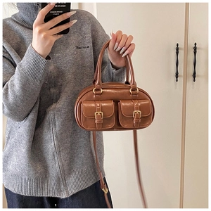 Detail of vintage brown PU leather bowling bag with twin front pockets and gold hardware