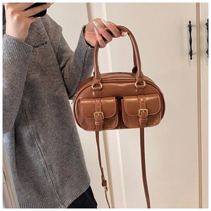 Detail of retro brown bowling bag showing dual front pockets and adjustable strap