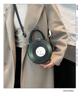 Detail of dark green PU leather record bag with musical elements and metal feet