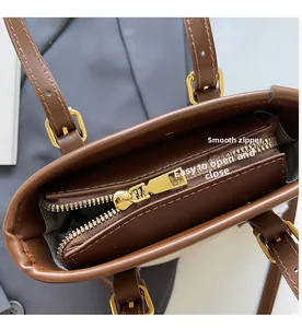 Détail de la fermeture éclair dorée et du cuir grainé d'un sac seau marron