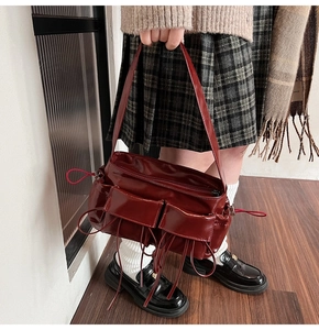 Detail of vintage burgundy shoulder bag with glossy finish and two front square pockets
