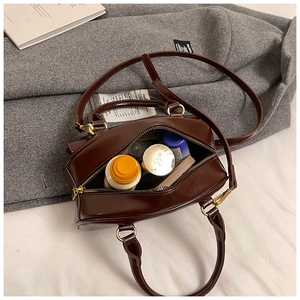 Interior detail of a vintage brown bowler bag showing its large capacity and smooth zipper