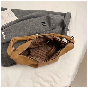 Interior view of soft brown leather tote showing striped lining and zipper pocket