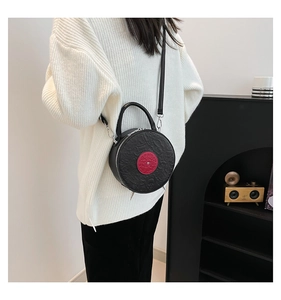 Detail of vintage record bag with skull patterns and red circular patch on model
