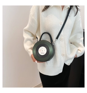 Detail view of a vintage record-shaped green crossbody bag with musical element prints