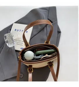 Vue intérieure du sac seau en toile beige avec lanières en cuir brun et grand rangement