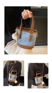 Détail du sac seau en denim bleu et cuir marron avec un charme en peluche doux