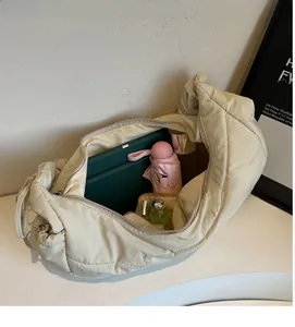 Spacious interior of beige quilted nylon puffer bag showing daily essentials and storage