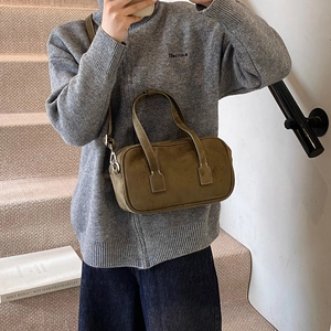 Retro olive green suede Boston bag with double handles and shoulder strap shown on model