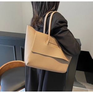 Détails du sac cabas en cuir grainé kaki porté à l'épaule par un mannequin