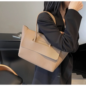Vue détaillée du grand sac cabas en cuir grainé kaki porté par un mannequin en décor