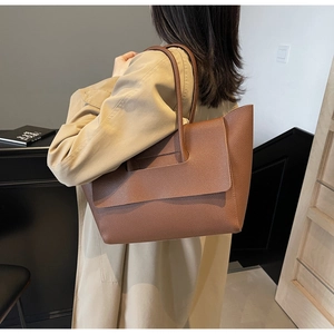 Détail du sac cabas en cuir litchi caramel avec rabat géométrique et large bandoulière