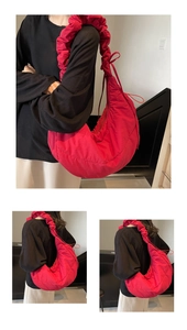 Detailed close-up of vibrant red quilted dumpling bag with stylish ruched drawstring strap