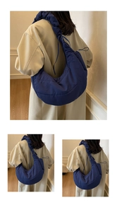 Close-up of dark blue quilted dumpling bag with unique ruched shoulder strap and drawstring