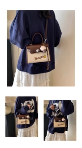 Detail of a vintage canvas and leather patchwork handbag with embroidery and ice cream charm