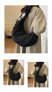 Detail view of black quilted nylon moon bag featuring pleated straps and fluffy texture
