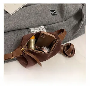 Detail shot of brown suede crossbody bag showing interior capacity and zipper pocket