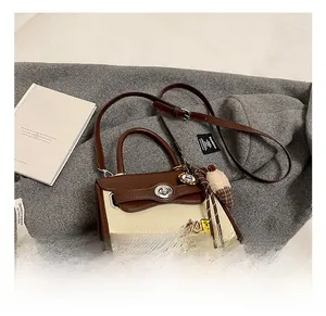 Close-up of retro crossbody bag featuring brown leather, beige fabric, and metal twist lock