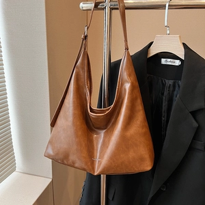 Brown large capacity vintage PU leather hobo tote bag displayed on a hanger