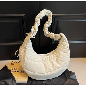 Detail of quilted cream nylon crescent bag with ruched strap and drawstring accents