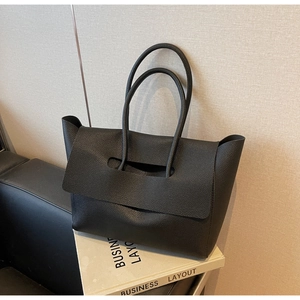 Détail du grand sac cabas en cuir grainé noir avec rabat et poignées doubles robustes