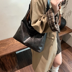 Large dark brown leather tote bag with a vintage finish and silver logo branding