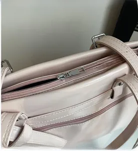 Close-up of smooth silver zipper and stitching on the pink minimalist leather tote bag