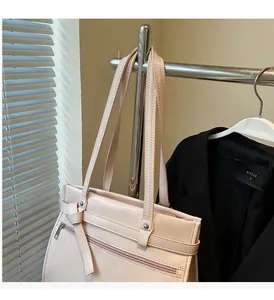 Detail of light pink tote bag with glossy finish and silver metal zipper on hanger