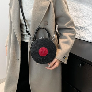 Fashionable black vinyl record shaped round crossbody bag with red center and embossed details