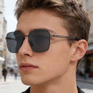 Detail of square polarized sunglasses for men with thin metal temples on a male model