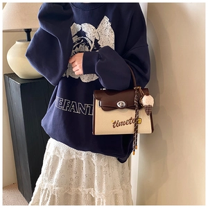 Detail of canvas crossbody bag with leather flap, embroidery and ice cream charm