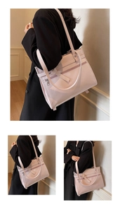 Detail view of pink large capacity tote bag with silver zippers and smooth faux leather finish