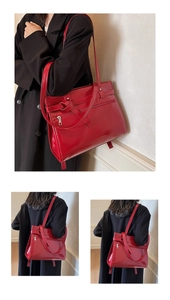 Macro detail of glossy red leather tote bag with decorative ties and zipper pocket