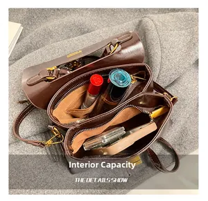 Detailed top view of brown leather bag interior showing dual compartments and storage