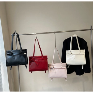 Group shot of glossy retro bucket bags in black, red, pink, and beige with bow details