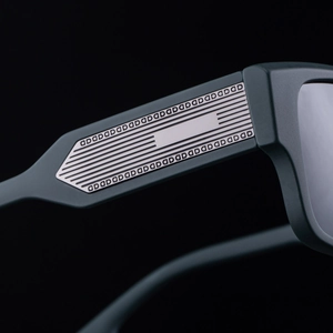 Detail of matte square sunglasses featuring a silver metal temple with embossed QD pattern