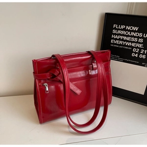 Macro shot of glossy red patent leather surface with smooth zipper detail and texture